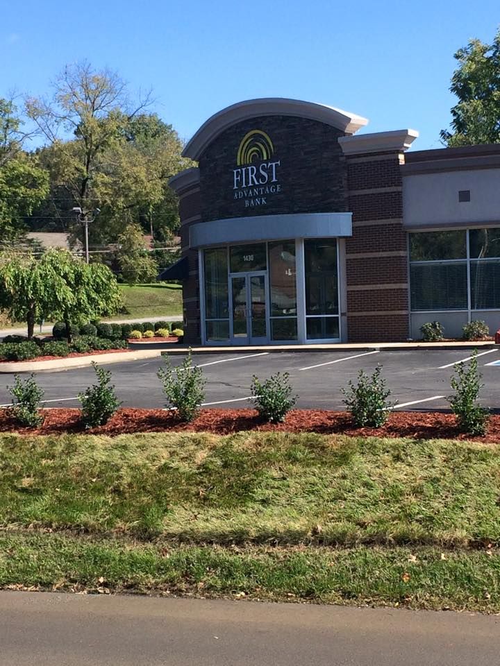 Exterior of First Community Bank building. Brick facade, large windows, blue sky.