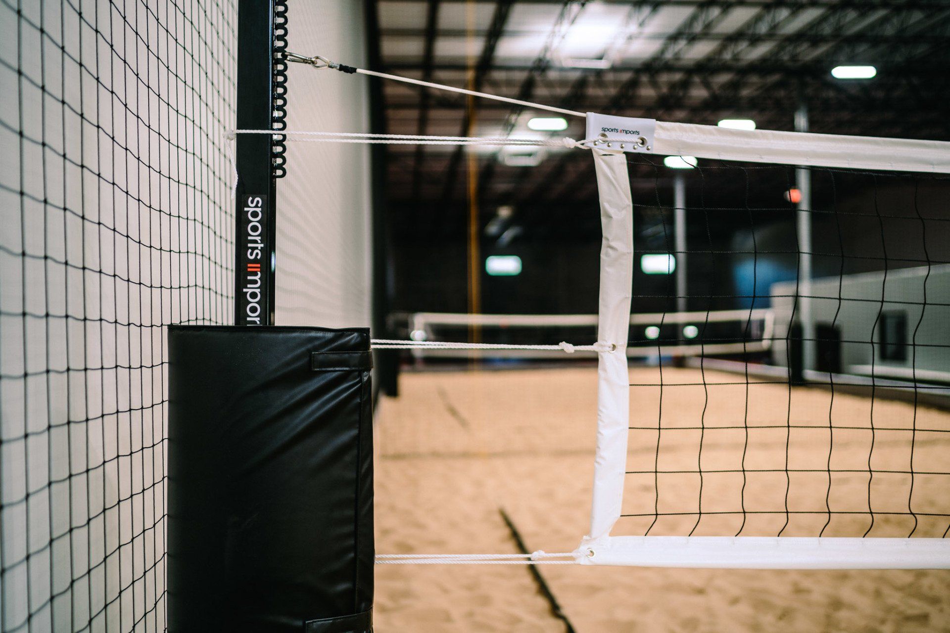 A volleyball net is sitting in the middle of a volleyball court.