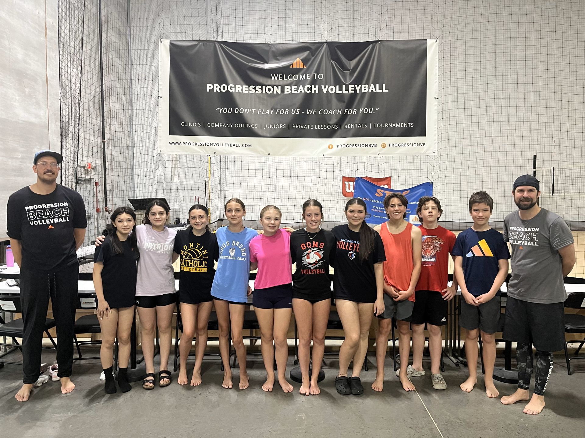 A group of young people are posing for a picture in front of a banner.