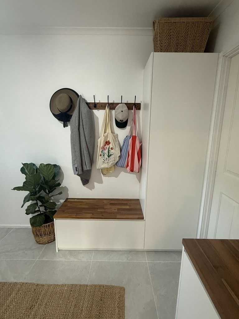 A Hallway With a Bench , Clothes Hanging on Hooks , and a Plant — JPR Concepts in Burleigh Heads, QLD