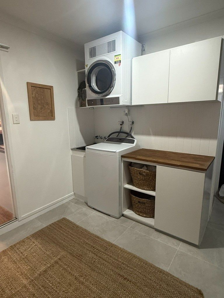 A Laundry Room With a Washer and Dryer and a Rug — JPR Concepts in Burleigh Heads, QLD