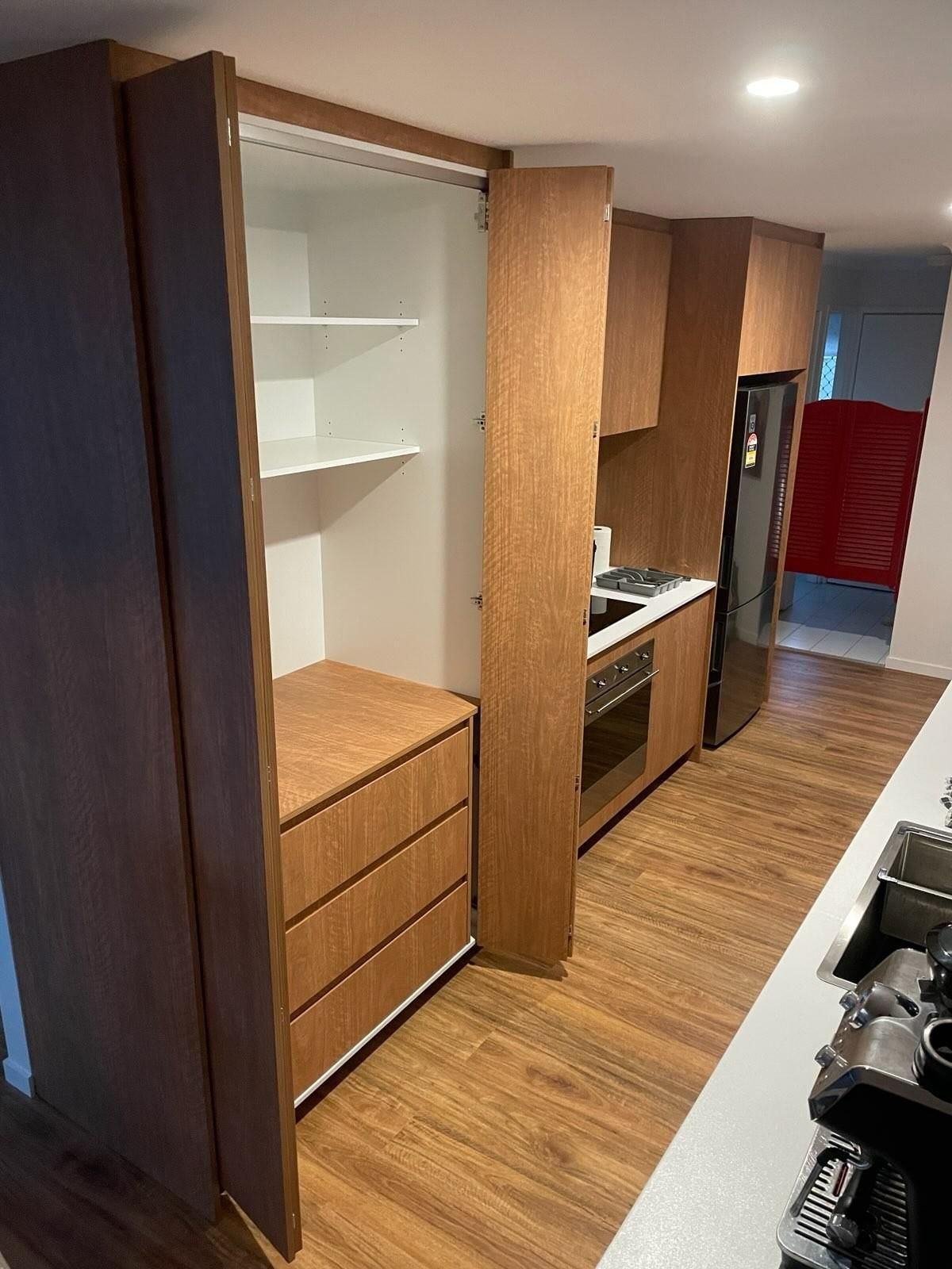A Kitchen With Wooden Cabinets, a Stove, a Refrigerator, and a Sink — JPR Concepts in Burleigh Heads, QLD
