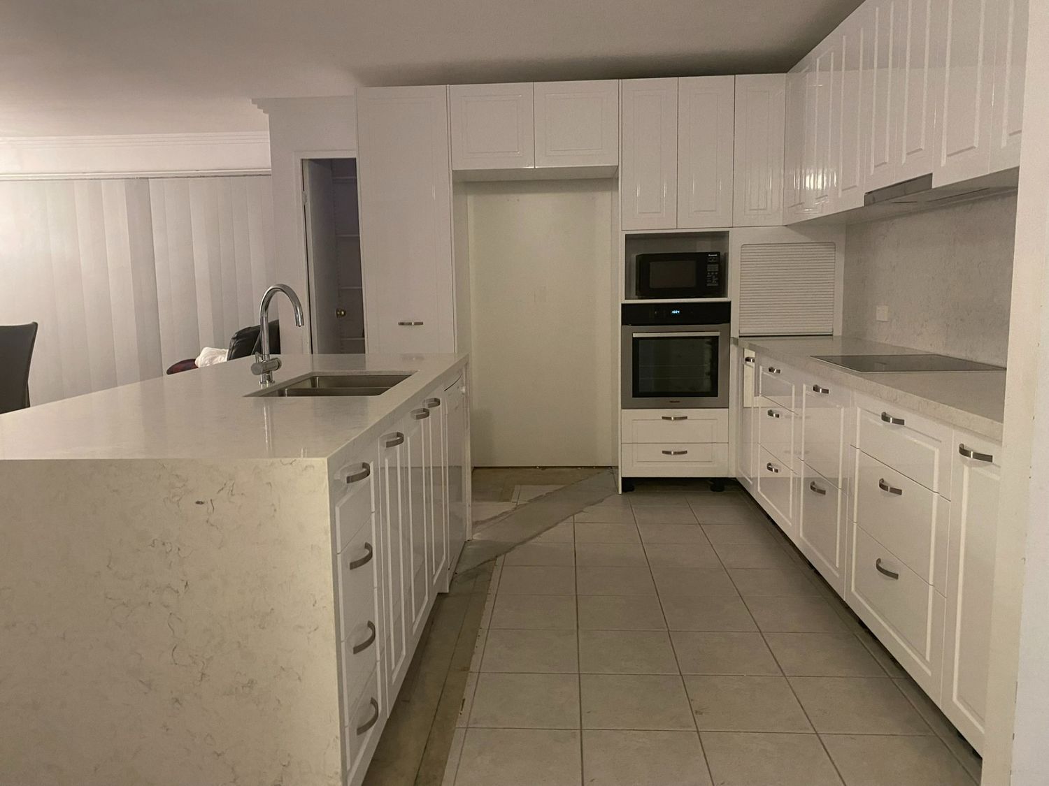 A Kitchen With White Cabinets , a Sink , and a Microwave — JPR Concepts in Burleigh Heads, QLD