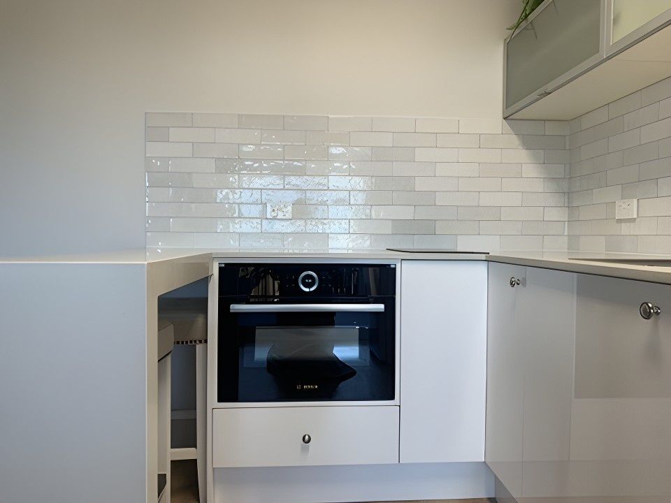 A Kitchen With White Cabinets and a Black Oven — JPR Concepts in Burleigh Heads, QLD