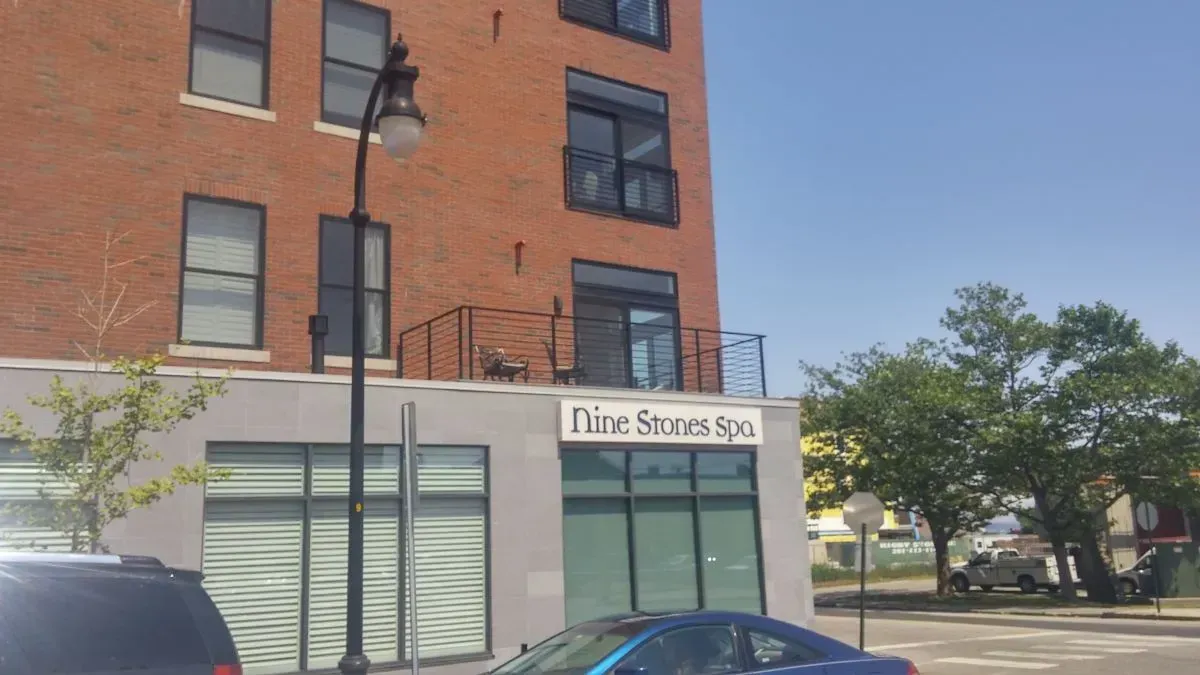 A blue car is parked in front of a brick building.