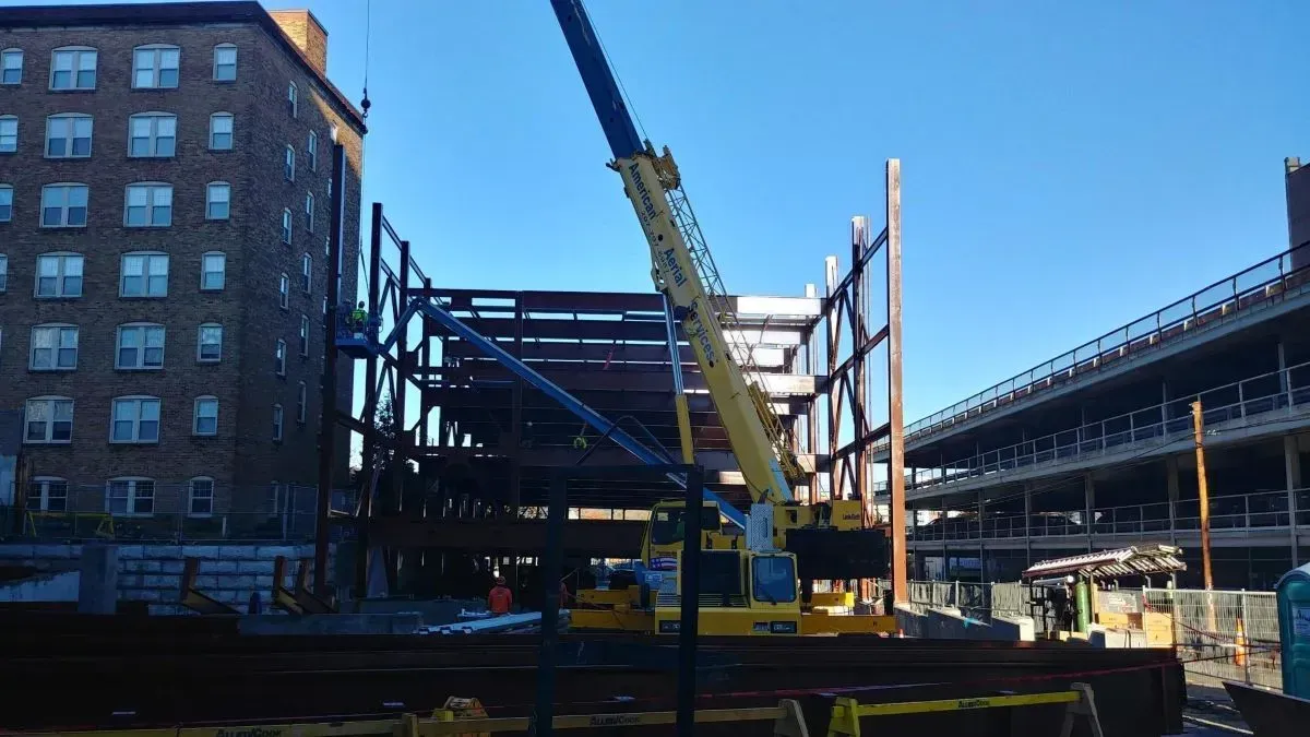 A construction site with a crane and a building in the background
