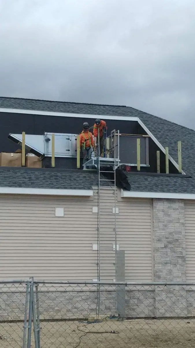 A group of men are working on the roof of a house.