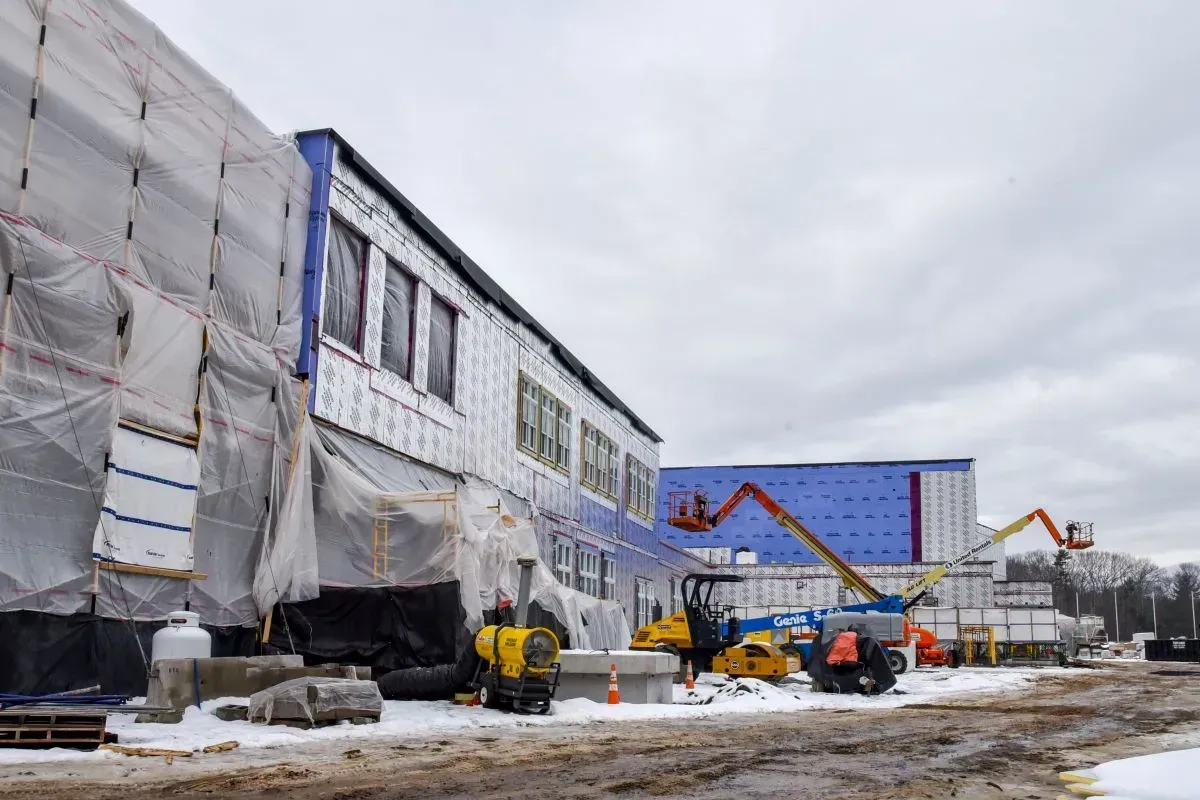A large building is being built in the snow.