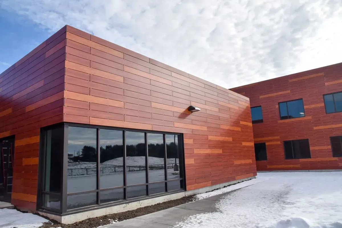 A large red building with a lot of windows and snow on the ground
