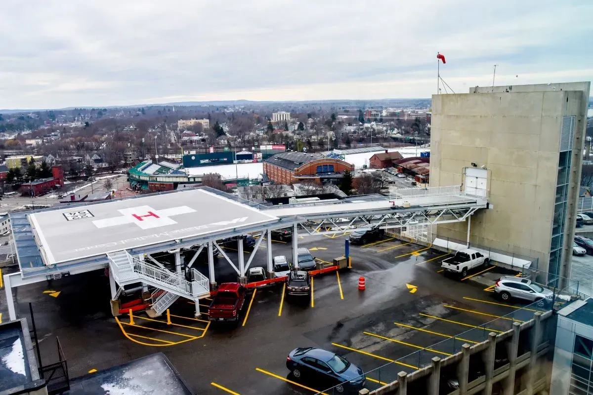 An aerial view of a parking garage with a helipad on top of it.