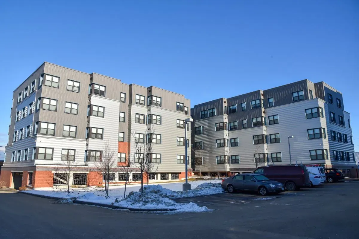 A large apartment building with cars parked in front of it.