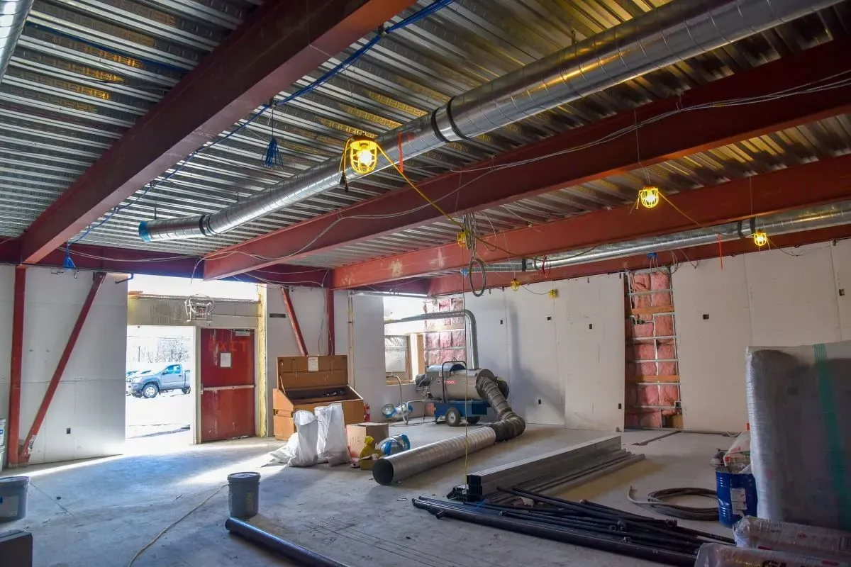 A large empty room with a metal ceiling and pipes.