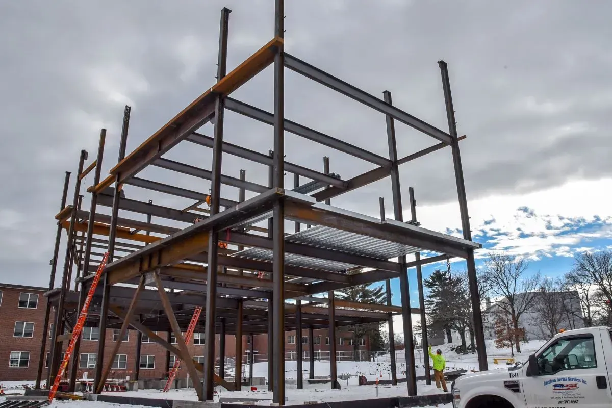 A white truck is parked in front of a building under construction.