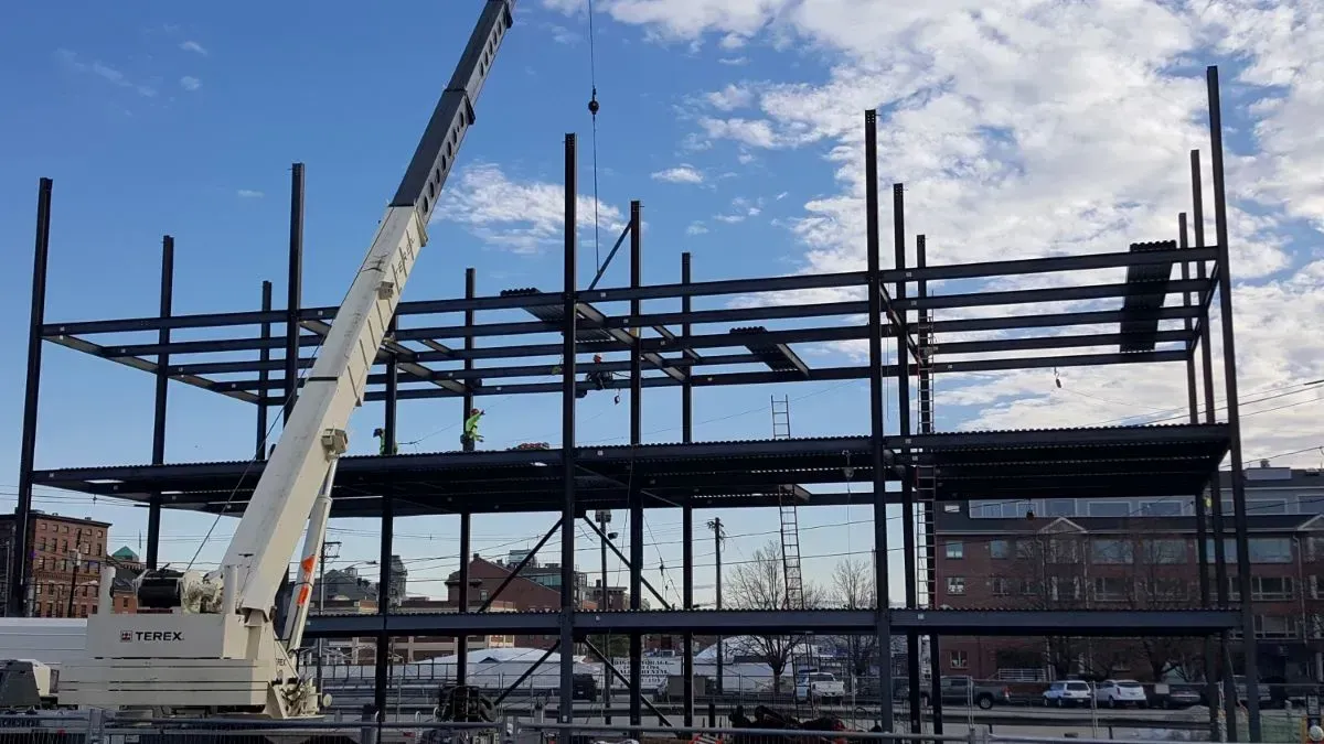 A large building under construction with a crane in the foreground.
