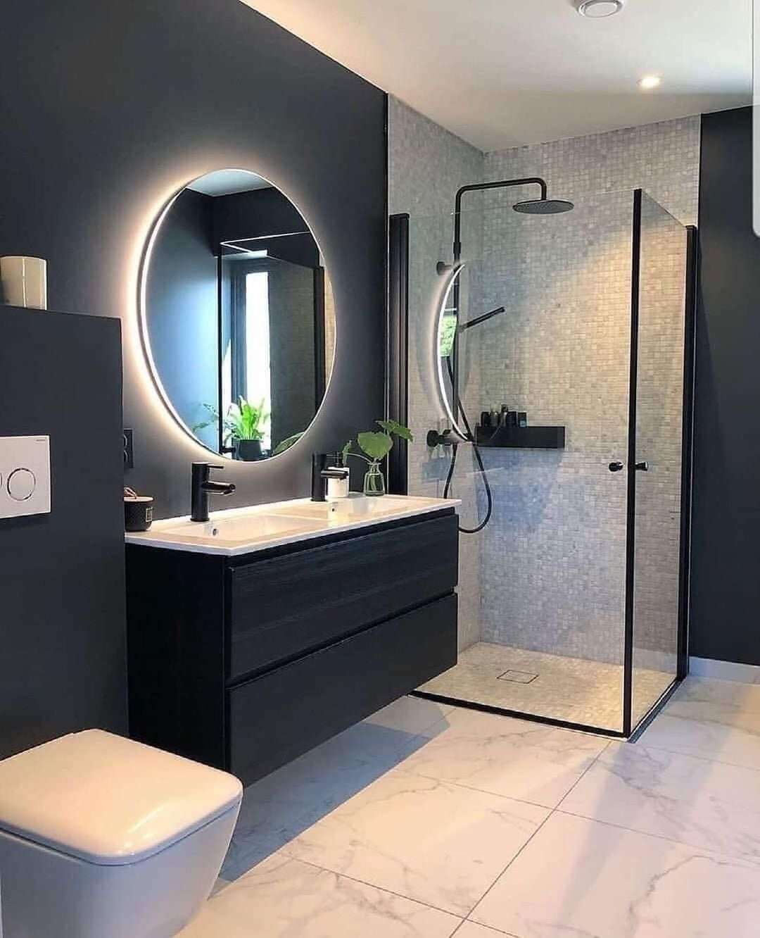 Modern bathroom with dark blue walls, black vanity, and a glass-enclosed shower.