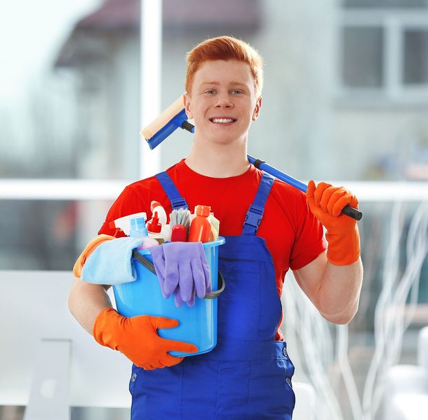 young janitor holding cleaning products tools