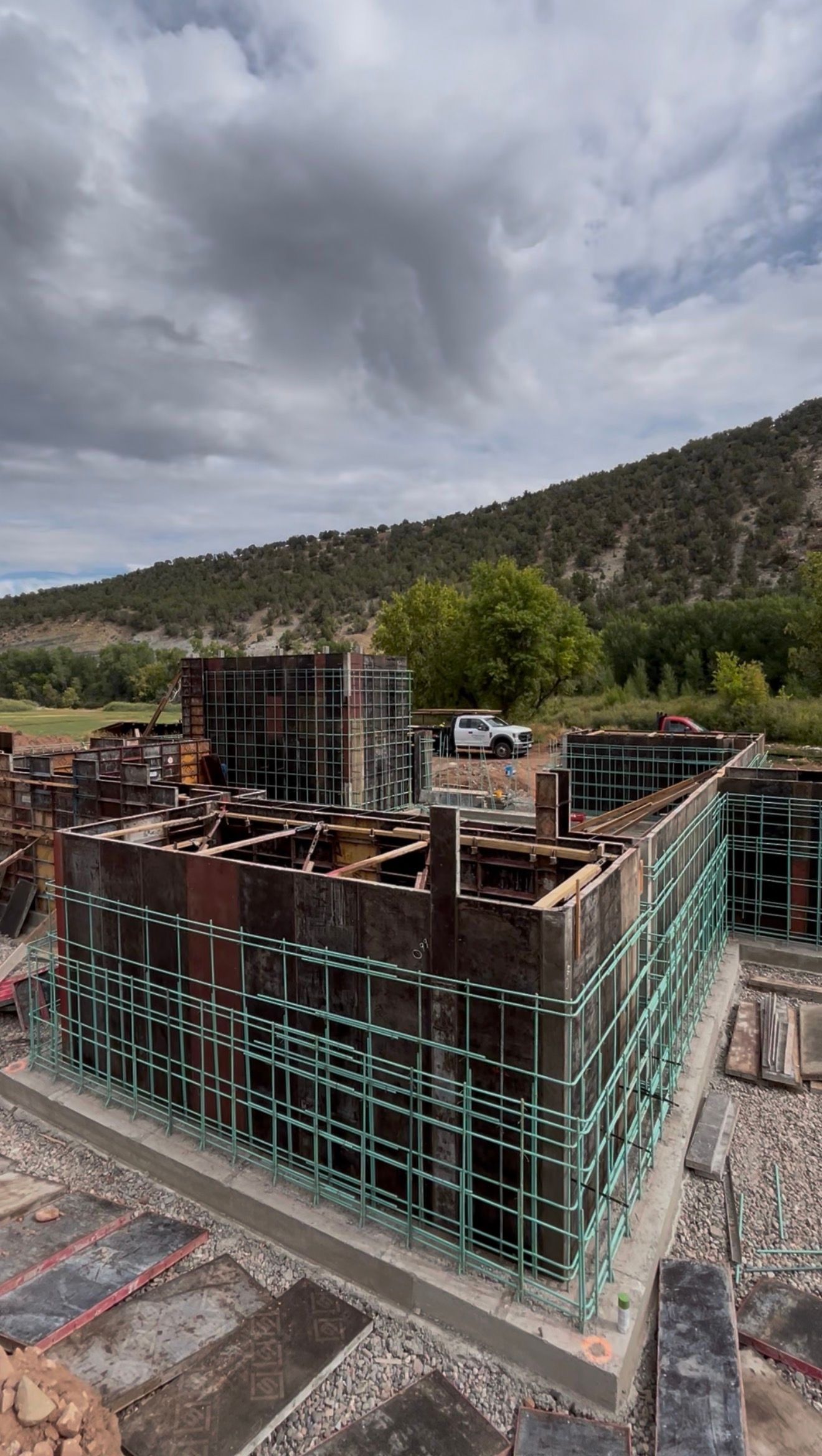 Beige two-story house with green garage door, stone accents, and blue sky.