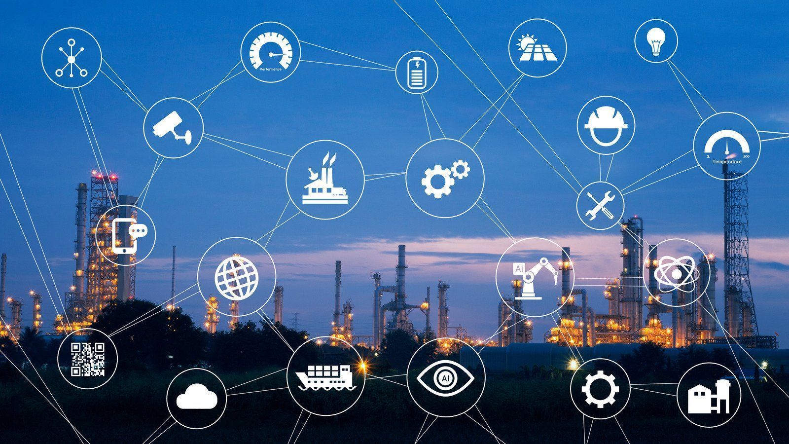 Factory at night with connected digital icons representing industrial IoT.