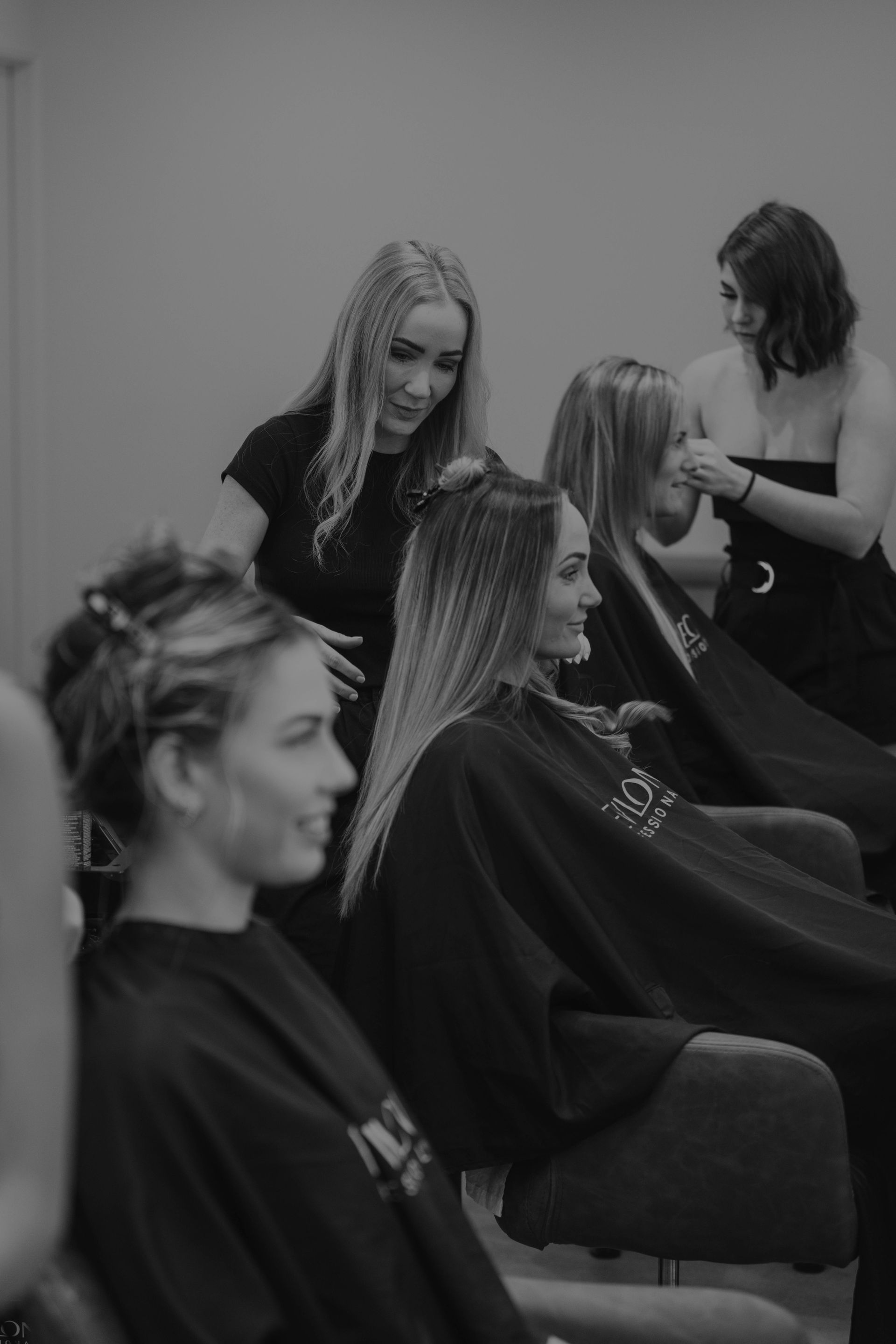 Hair stylists working on clients in a salon.