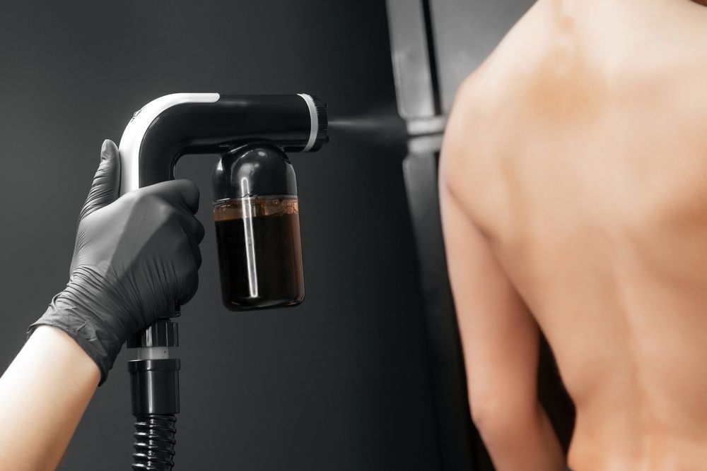 Person Receiving Spray Tan From a Professional — Salon South in Mount Sheridan, QLD