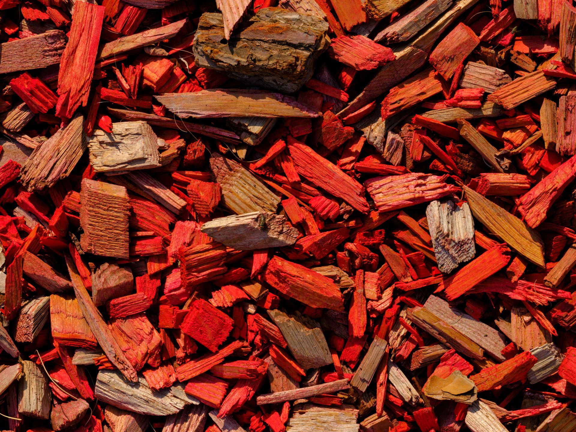 Red and brown wood chips scattered in a close-up textured pile.