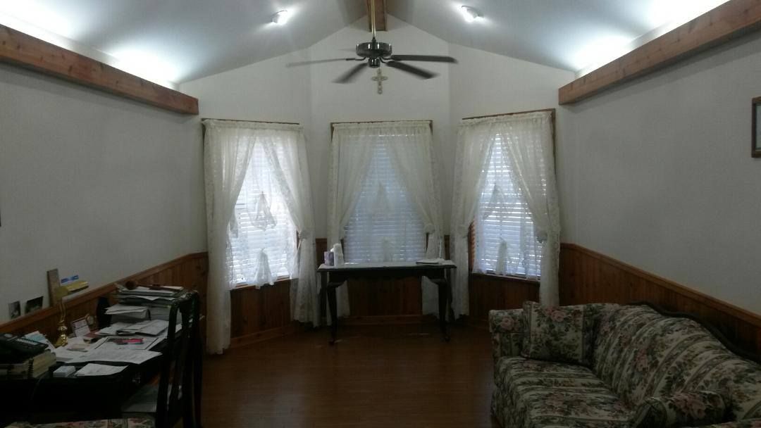 A living room with a couch a table and a ceiling fan