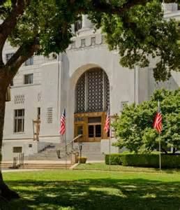 A large white building with a tree in front of it.