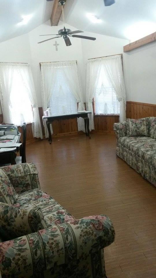 A living room with a couch , chairs , and a ceiling fan.