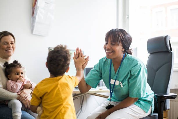 Healthcare professional giving a high-five to a child during a clinic visit.
