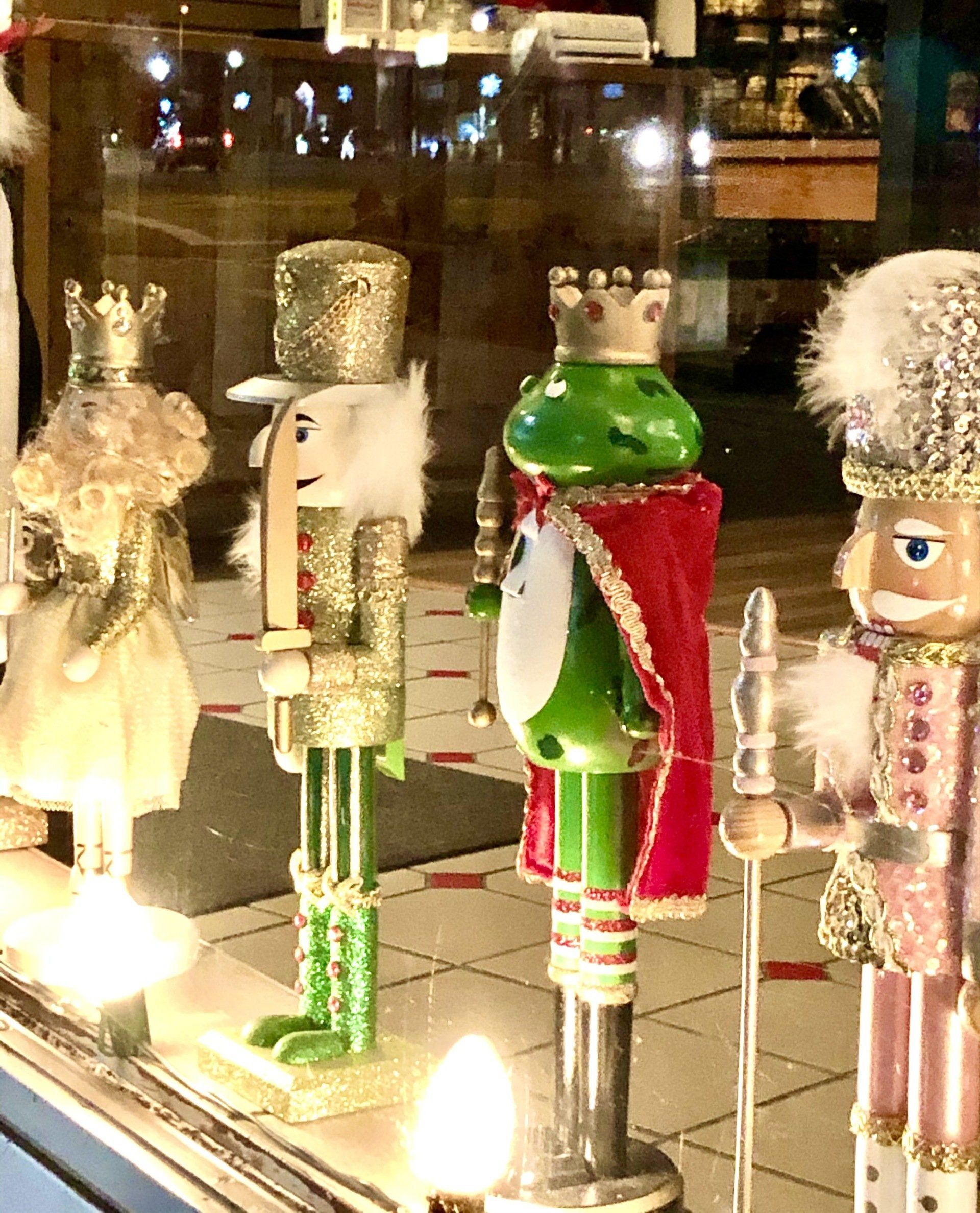 A group of nutcrackers are displayed in a window