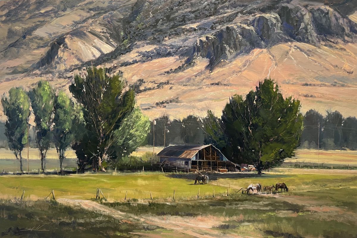 A painting of a barn and horses in a field with mountains in the background.