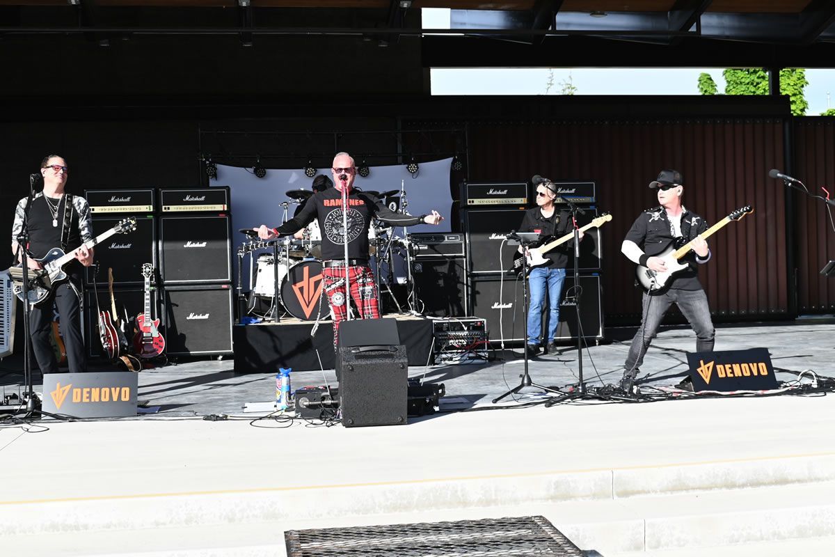 A band is playing on a stage with a banner that says Myer's Morturary
