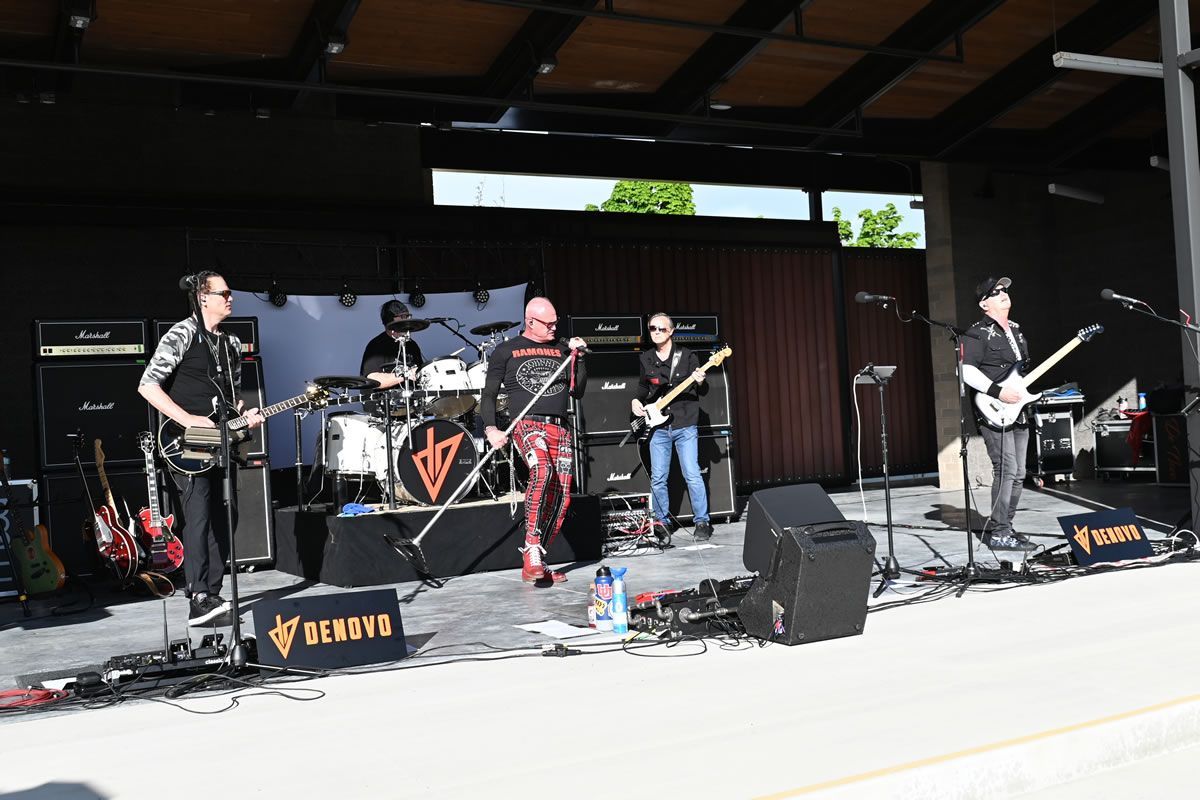A band is playing on a stage with a banner that says Myer's Morturary