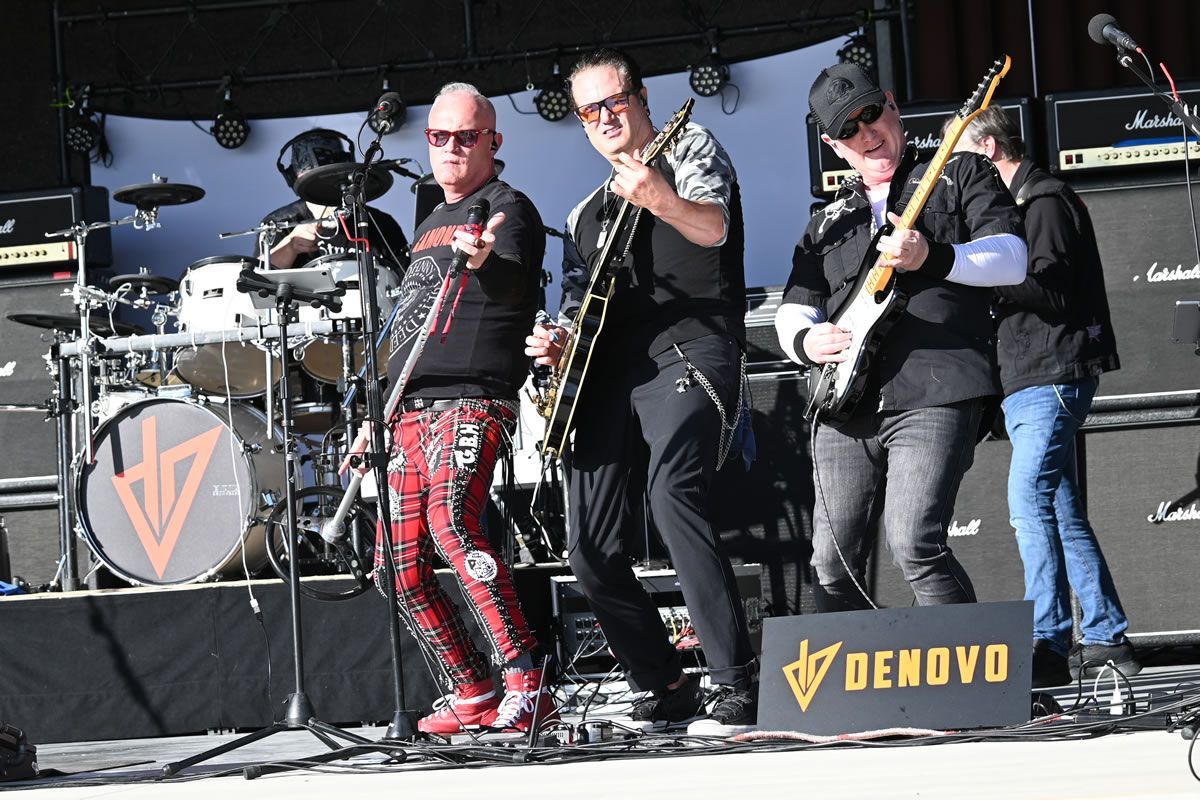 A band is playing on a stage with a banner that says Myer's Morturary