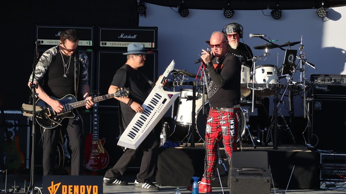 A band is playing on a stage with a banner that says Myer's Morturary