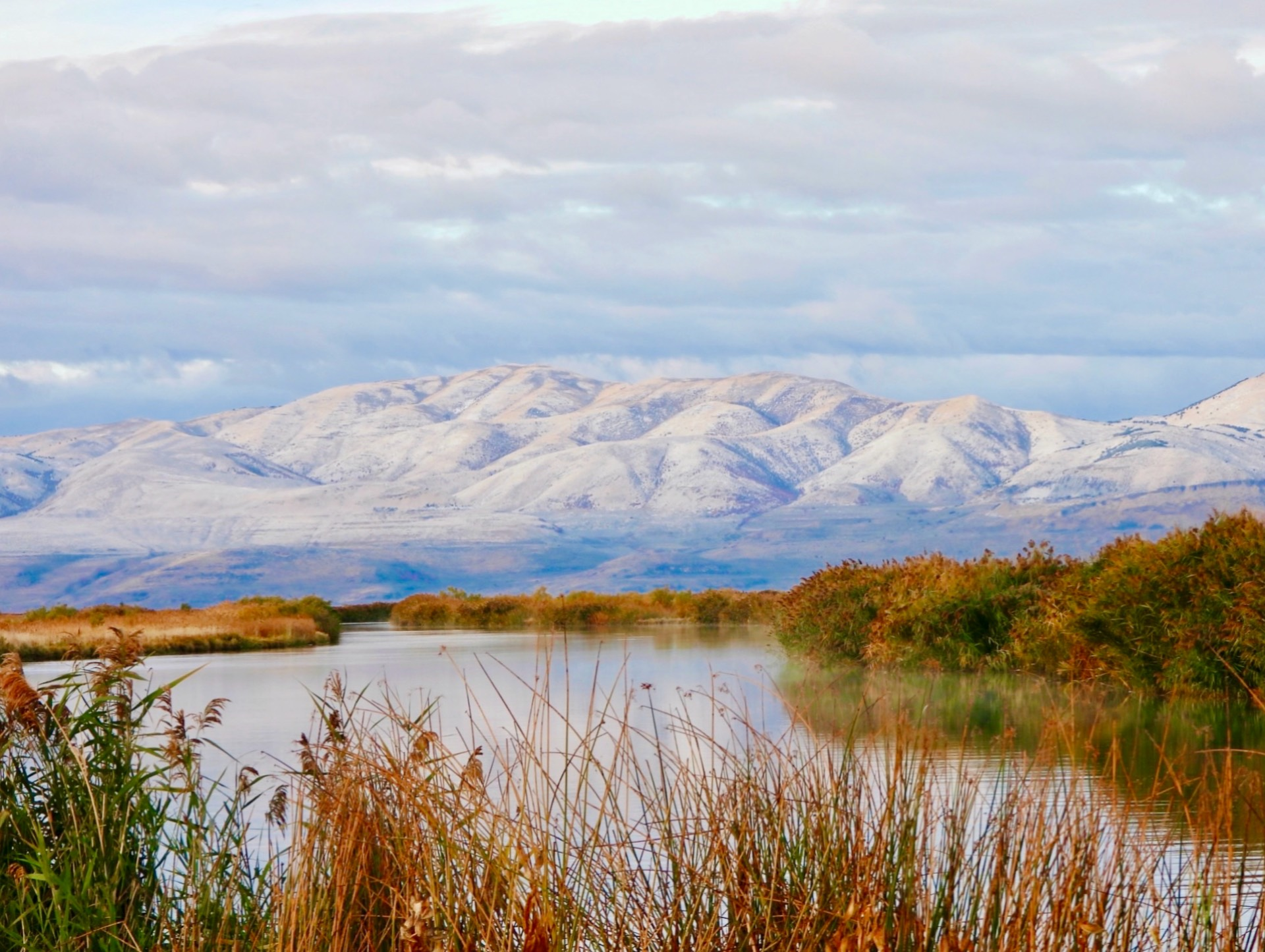 A lake with mountains in the background and snow on the mountains