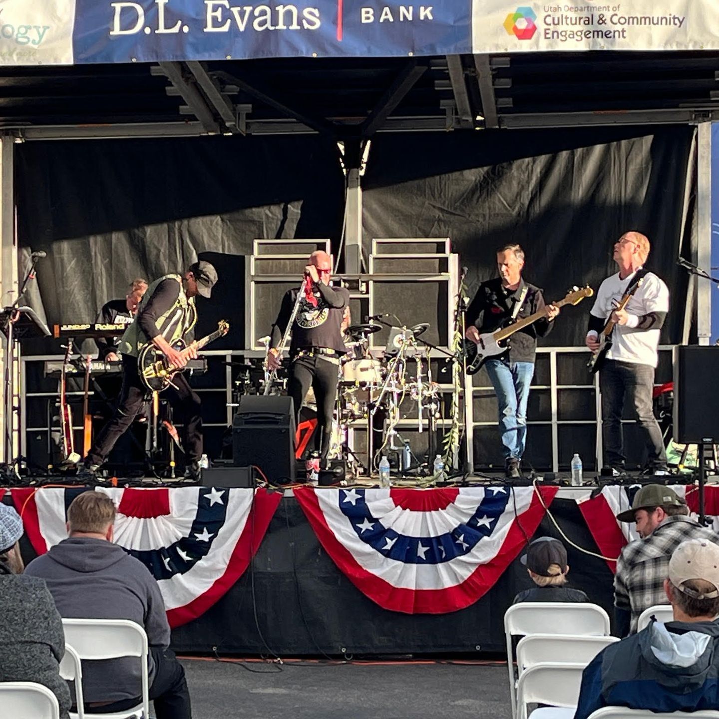 A band is playing on a stage with a banner that says d.l. evans bank