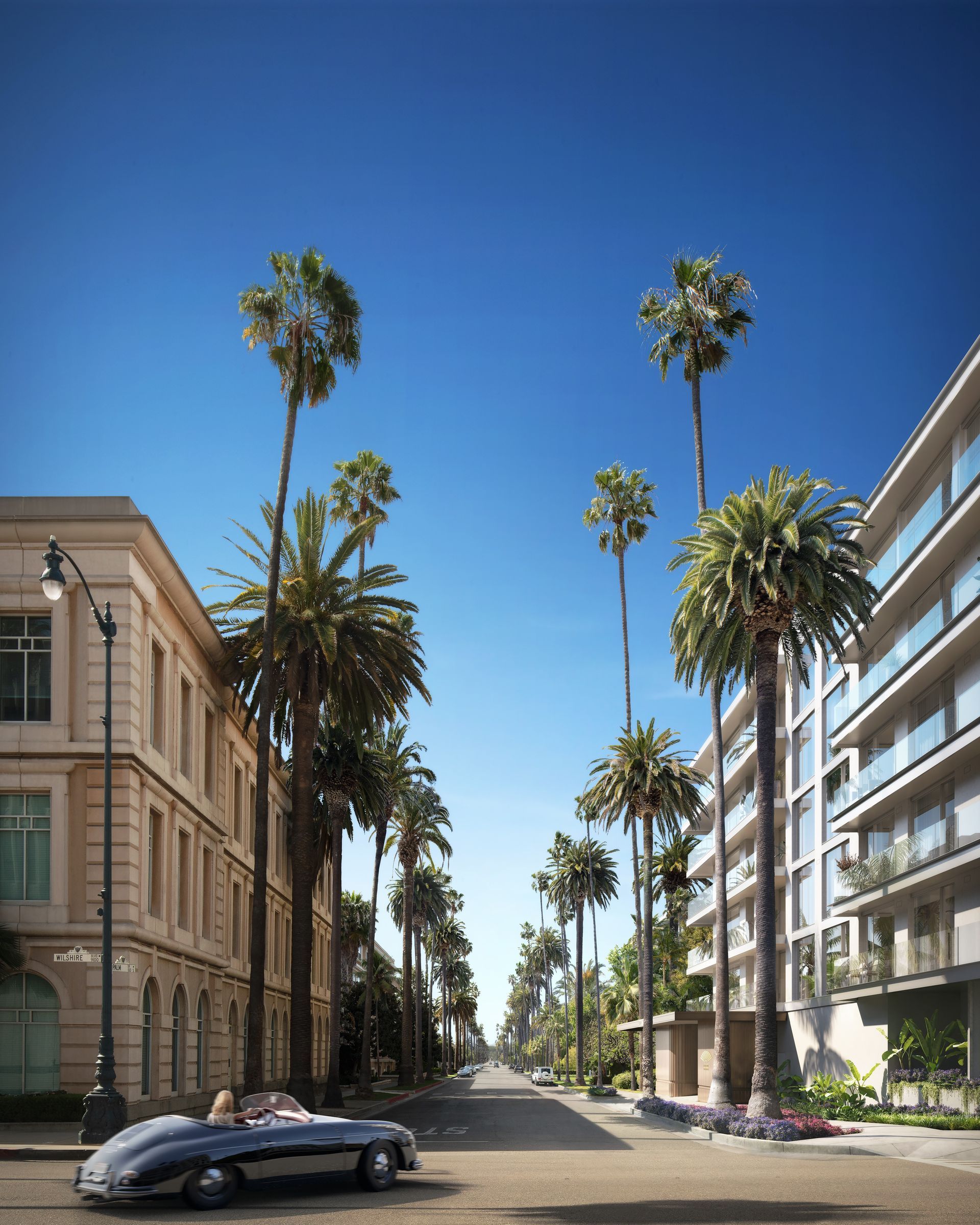 A car is parked on the side of a street surrounded by palm trees.