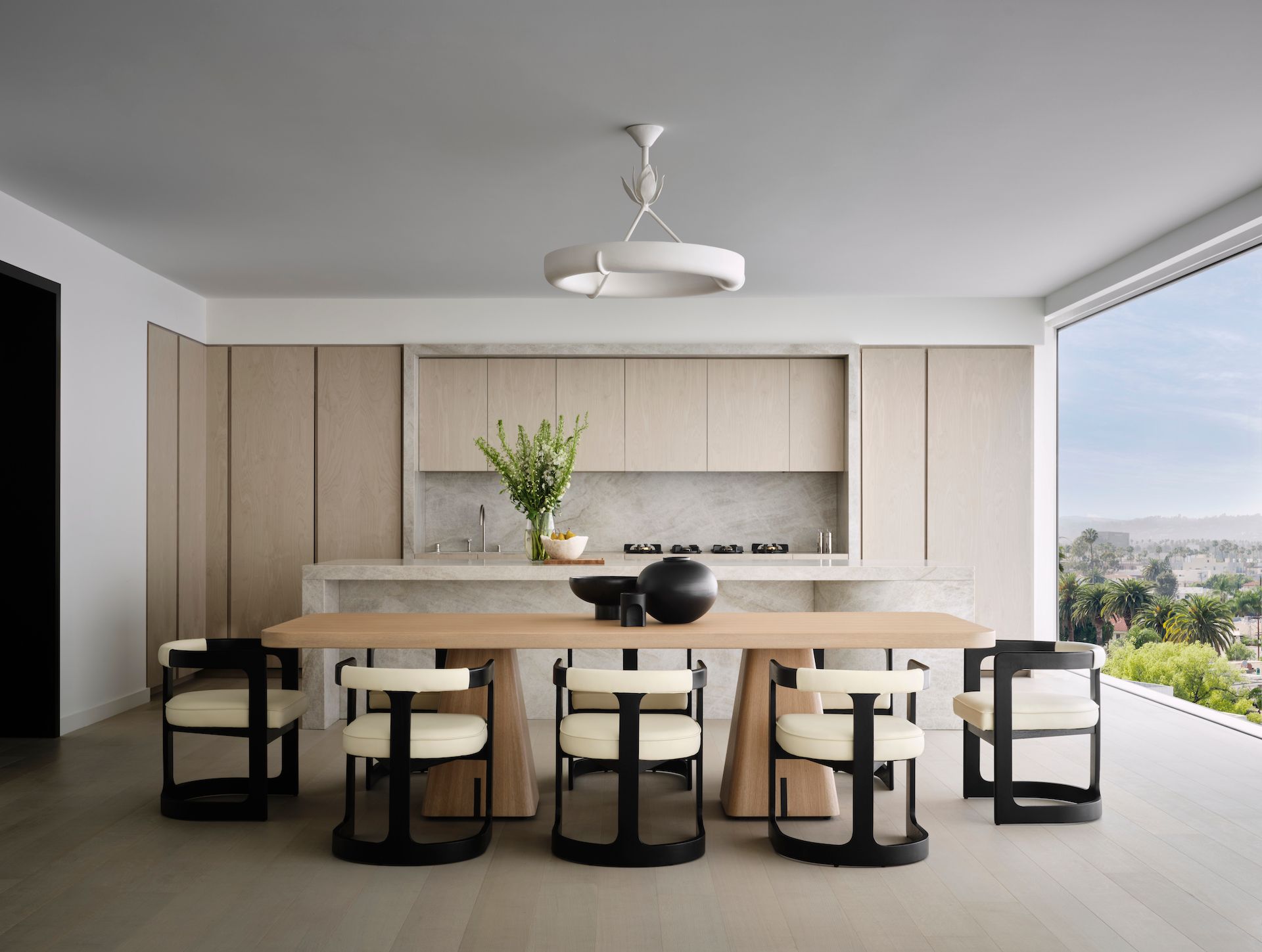 A dining room with a table and chairs and a large window.