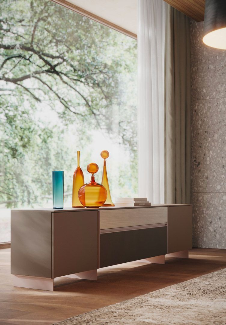 Mobile basso con vasi davanti a una grande finestra che si affaccia su un paesaggio verde.