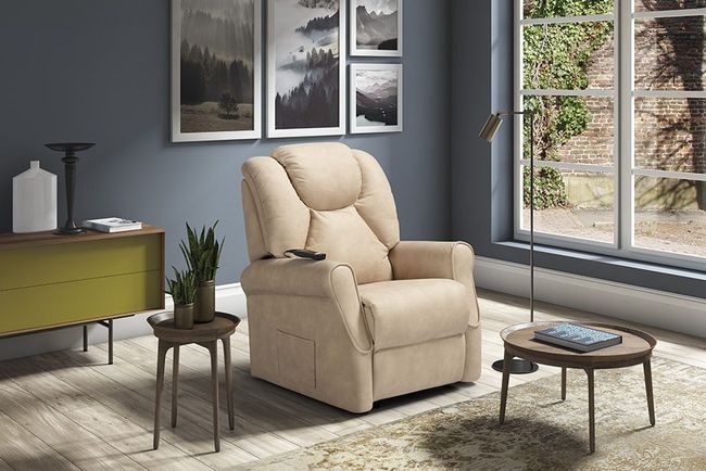 Poltrona reclinabile beige in un soggiorno con opere d'arte e un tavolino.
