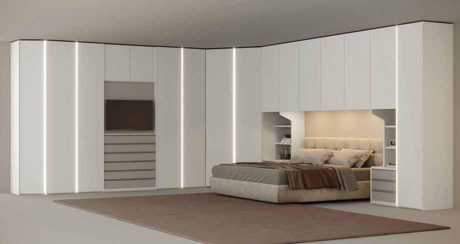 Camera da letto moderna con armadio bianco a muro, letto, cassettiera e tappeto. Include luci soffuse e TV.