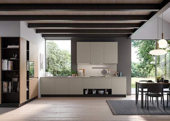 Cucina moderna con mobili chiari, ampie finestre, travi scure e zona pranzo.