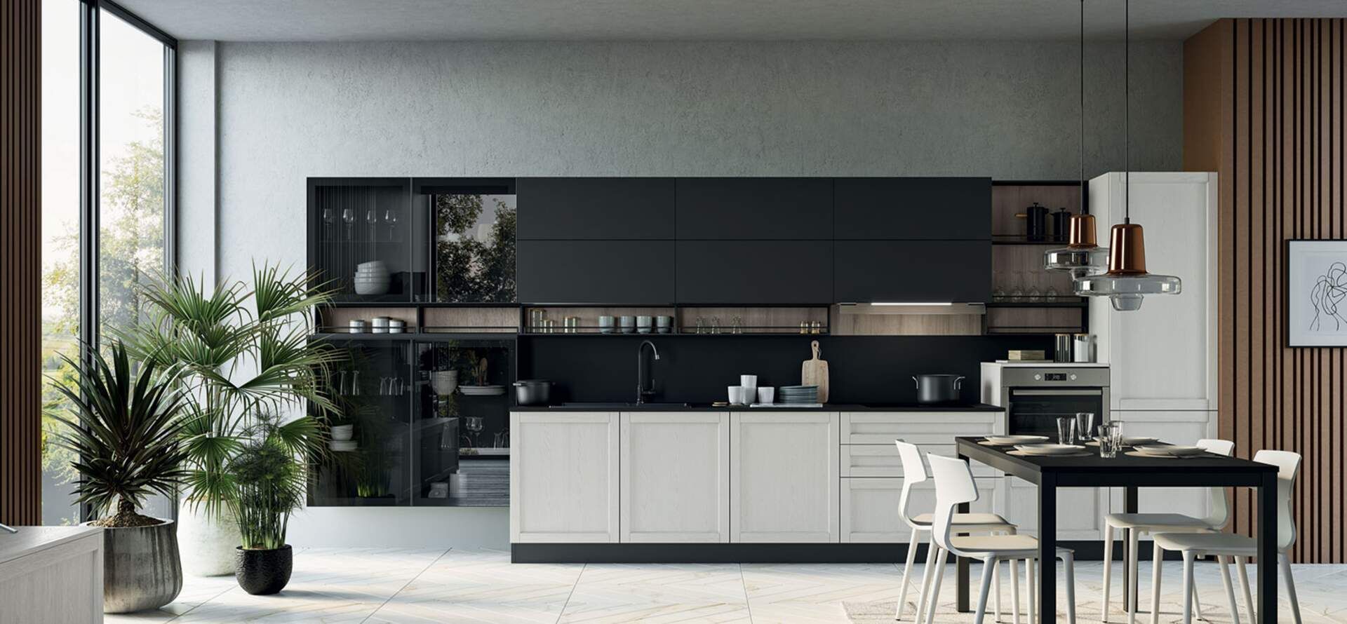 Cucina moderna con mobili bianchi e neri, piante e tavolo da pranzo. La luce naturale inonda la stanza.