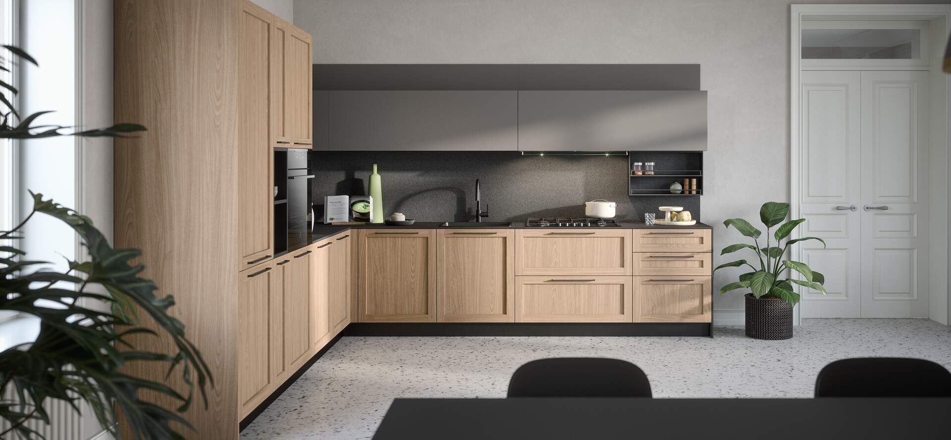 Cucina moderna con mobili in legno chiaro, pensili grigi e piano di lavoro scuro.