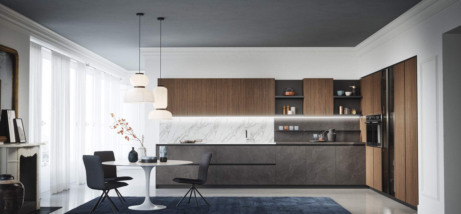 Cucina moderna con mobili in legno, isola, tavolo da pranzo e lampade a sospensione. Tonalità di grigio e marrone.