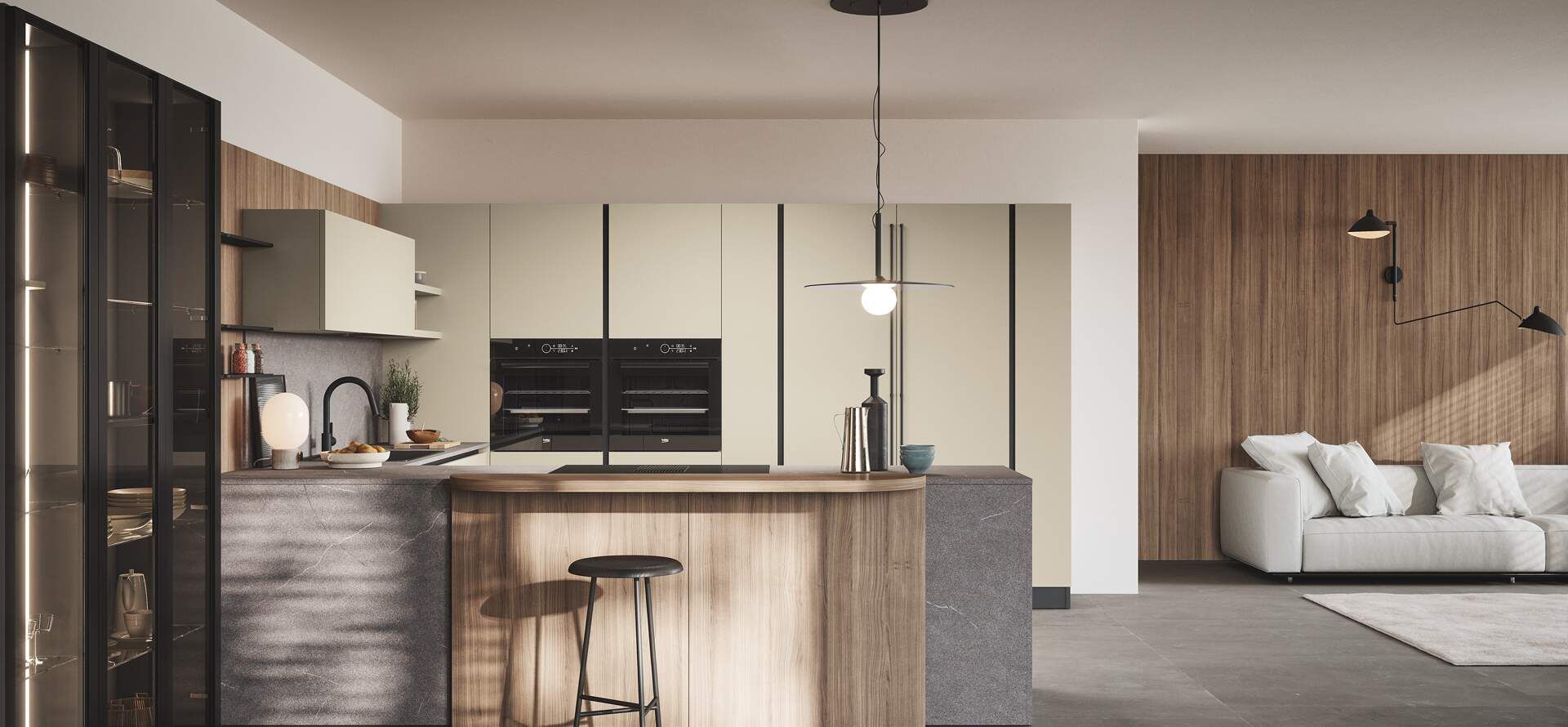 Cucina moderna con isola in legno, elettrodomestici scuri e zona soggiorno con divano bianco e pannelli in legno.