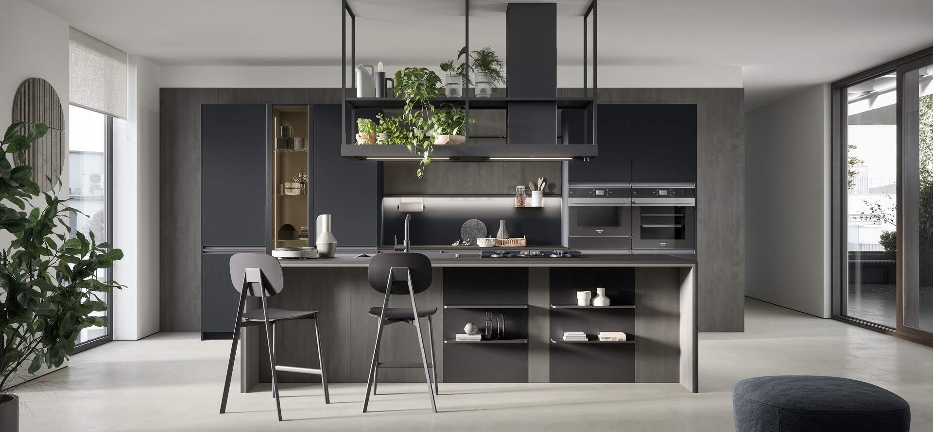 Cucina moderna con mobili grigio scuro, isola e sgabelli da bar. Piante appese alle mensole superiori.