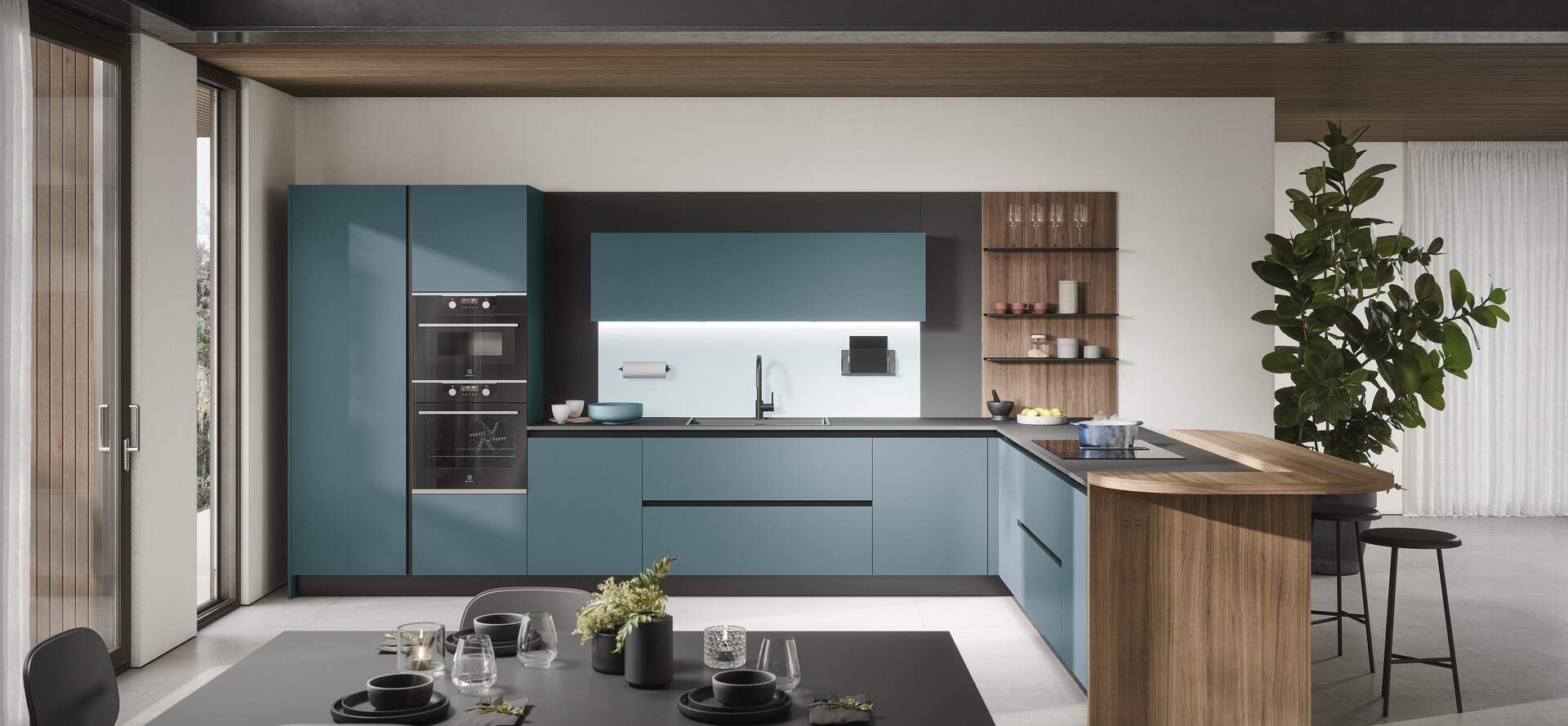 Cucina moderna con mobili color verde acqua, dettagli in legno e un grande albero.