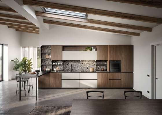 Cucina moderna con mobili in legno, ripiani chiari e lucernario.